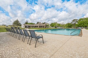 A swimming pool with a tiled deck and chairs, surrounded by a fence and trees. - Premium Cabin - Family Cabin Rental Sleeps 8-10 (Willis)