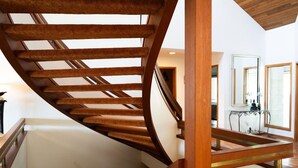 A spiral staircase with wooden railings and a glass floor, leading to an upper level. - Stunning Vineyard Estate House (Kelowna)