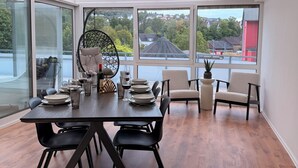Un comedor moderno con una mesa de madera dispuesta para cuatro personas, rodeada de sillas negras.