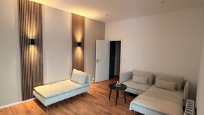 Una sala moderna con dos sofás, una mesita de centro y suelo de madera.