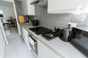A modern kitchen with a built-in stove, a coffee maker, and a microwave. - Modern 3BR | Sleeps 6 | Free Parking | Central London (London)