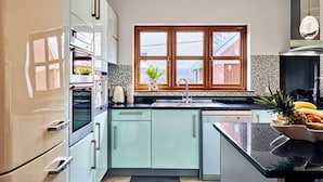 Eine moderne Küche mit Fenster, einer Spüle und einer Arbeitsplatte mit Früchten.