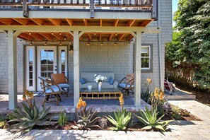A covered patio with seating, a brick wall, and a garden with plants. - Breezy, Bright 1 Bedroom Apartment 3 Blocks to Ledbetter Beach and Harbor (Santa Barbara)