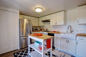 A modern kitchen with white cabinets, stainless steel appliances, and a wooden countertop. - Breezy, Bright 1 Bedroom Apartment 3 Blocks to Ledbetter Beach and Harbor (Santa Barbara)