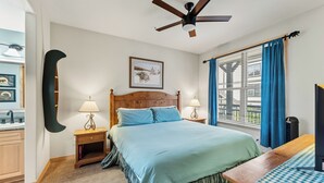 A bedroom with a bed, bedside tables, a ceiling fan, a window with curtains, and a wall-mounted picture. - Walk to Peak 9, Quicksilver Lift & Main St - Private Hot Tub & Garage (Breckenridge)