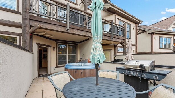 An outdoor patio with a round table, chairs, a grill, and a hot tub. - Walk to Peak 9, Quicksilver Lift & Main St - Private Hot Tub & Garage (Breckenridge)