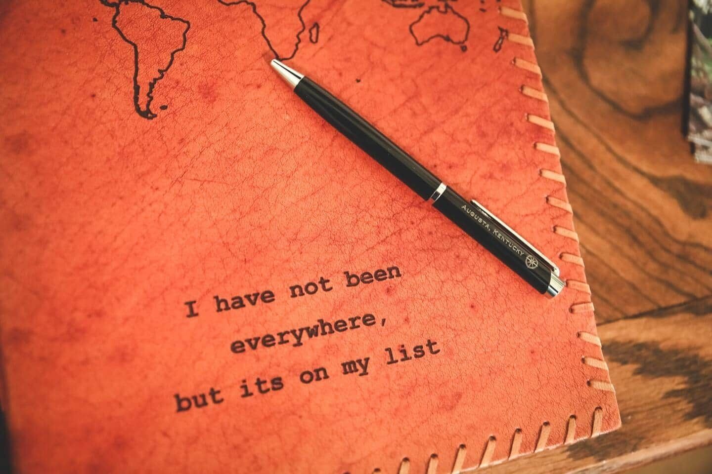 Un carnet avec un stylo posé dessus, et une citation imprimée sur la page.