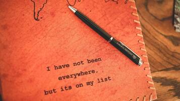 Un carnet avec un stylo posé dessus, et une citation imprimée sur la page.