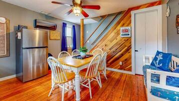 A compact kitchen with a refrigerator, dining table, and chairs.