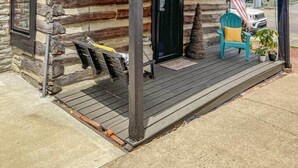 Eine Blockhütte mit Veranda, einer Flagge und einem Stuhl.