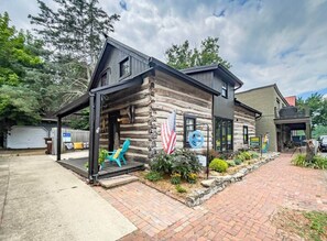 A log cabin with a porch, a flag, and a sign indicating an office.