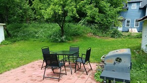 A patio with a grill, a table, and chairs. - Newly renovated, New England 3-bedroom home in Skowhegan. (Skowhegan)