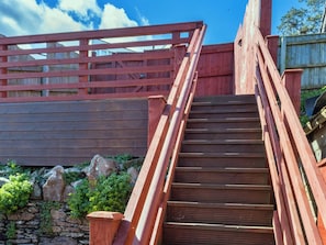 Eine Holztreppe mit Handlauf, die zu einer Holzterrasse führt.