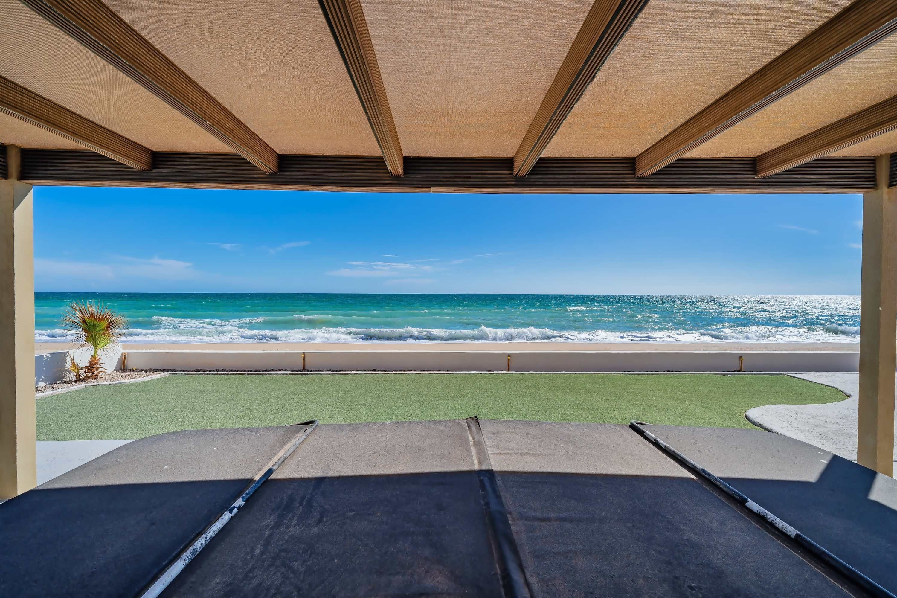 Vista a la playa desde un espacio cubierto con mesa de billar.