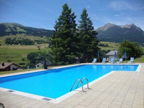 A swimming pool with a view of mountains and a clear sky. - Tgesa Sunnmatt Nr 46 Appartement/Fewo, Dusche, WC, 1 Schlafraum by Interhome (Savognin)