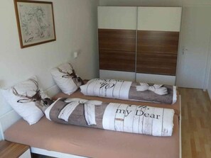 A bedroom with a bed, a nightstand, and a wardrobe. - Tgesa Sunnmatt Nr 46 Appartement/Fewo, Dusche, WC, 1 Schlafraum by Interhome (Savognin)