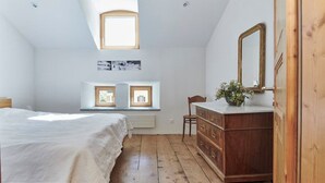 A bedroom with a bed, dresser, mirror, and two windows with pictures. - Palazzo Appartement/Fewo, Dusche, WC, 3 Schlafräume by Interhome (Bivio)