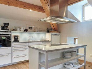A modern kitchen with a central island, built-in appliances, and a skylight. - Palazzo Appartement/Fewo, Dusche, WC, 3 Schlafräume by Interhome (Bivio)
