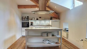 A modern kitchen with a central island, wooden beams, and a skylight. - Palazzo Appartement/Fewo, Dusche, WC, 3 Schlafräume by Interhome (Bivio)
