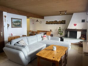 Una sala acogedora con un sofá seccional, una mesa de centro de madera y una chimenea.