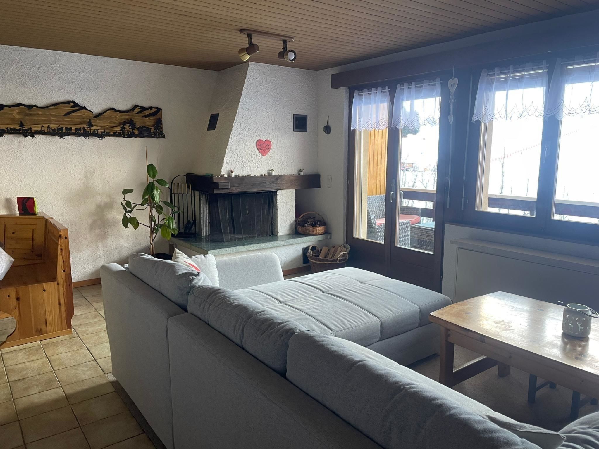 Un salon chaleureux avec un canapé, une petite table et une cheminée.