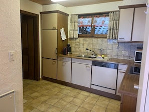 A compact kitchen with a refrigerator, a sink, and cabinets. - Ferienhaus Somareiva Appartement/Fewo, Dusche oder Bad, WC, 2 Schlafräume by Interhome (Savognin)