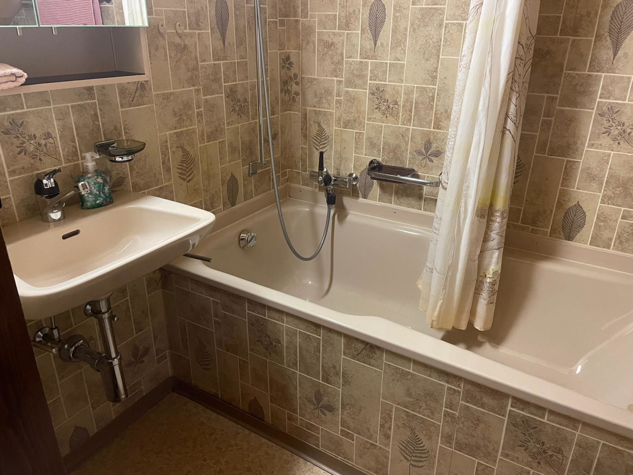 Een badkamer met een bad, een wastafel en een douche.