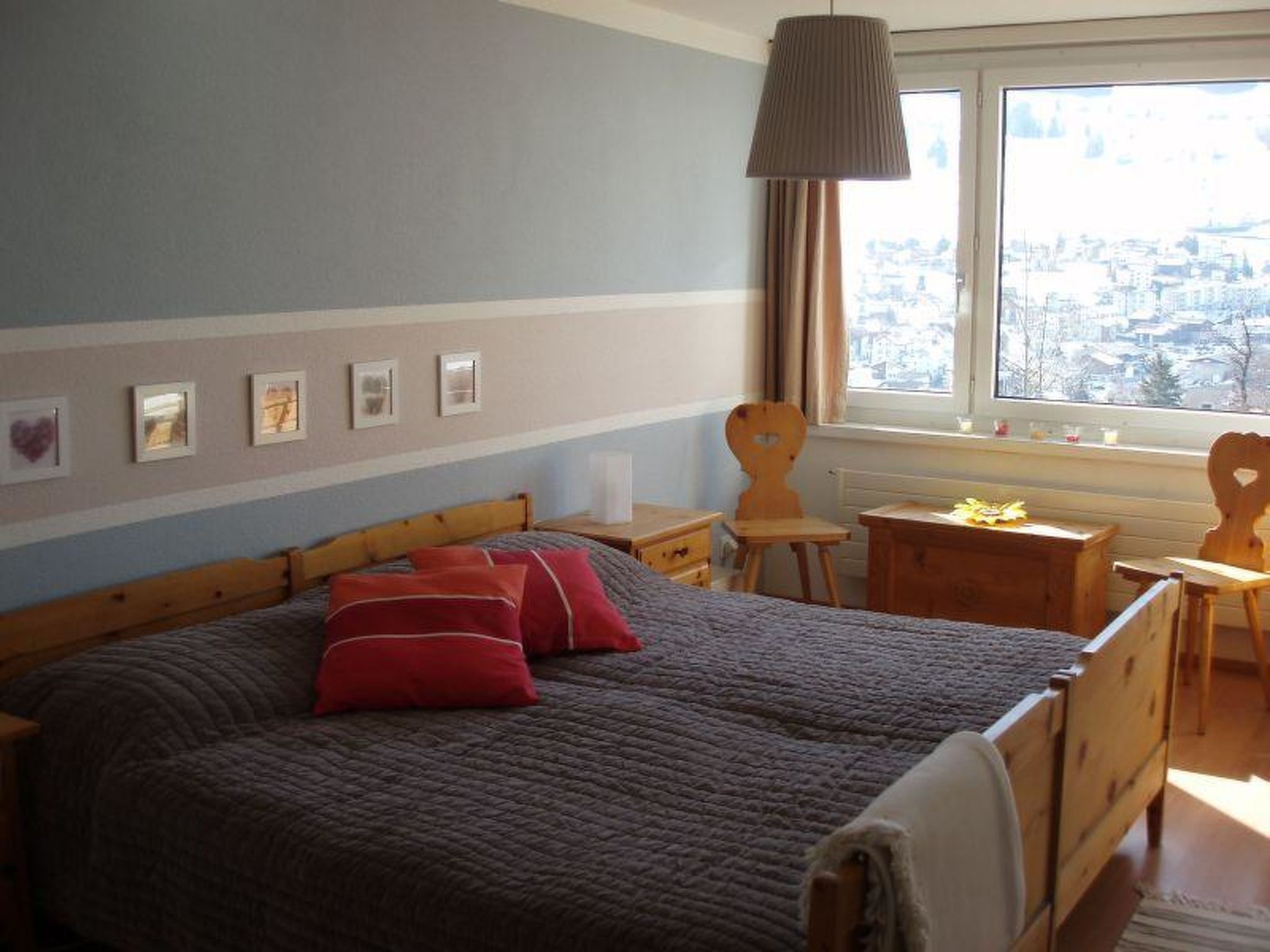 A bedroom with a large bed, a window with a view, and a bedside table.