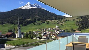 Un balcón con vistas a una montaña, una iglesia y un pueblo.