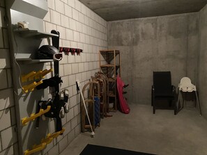 A storage room with shelves, hooks, and a chair.