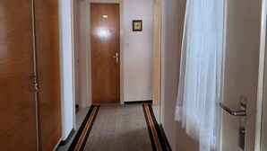 A narrow hallway with a wooden door at the end, a small framed picture on the wall, and a white curtain on the right. - Casa Fasciati Appartement/Fewo, Bad, WC, 4 oder mehr Schlafräume by Interhome (Bivio)