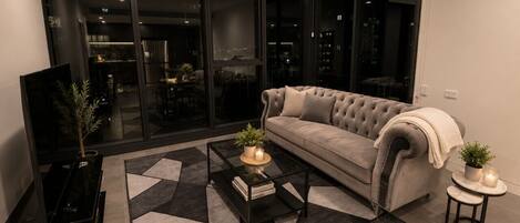 A modern living room with a sofa, coffee table, and a TV.