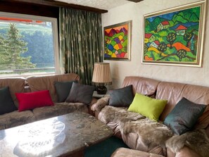 A living room with a sofa, a coffee table, and two paintings on the wall. - Haus Viols 54 Appartement/Fewo, Bad, WC, 2 Schlafräume by Interhome (Savognin)