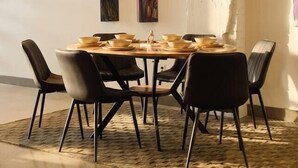 A dining area with a round table, black chairs, and a patterned rug. - Penthouse Loft, Central Downtown Dallas, Pool+Gym+Office, City Views (Dallas)