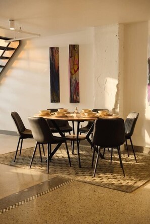 A dining area with a round table, black chairs, and a patterned rug. - Penthouse Loft, Central Downtown Dallas, Pool+Gym+Office, City Views (Dallas)