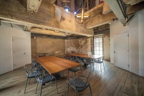 A spacious room with a large wooden table and chairs, a hanging light fixture, and a view through a window. - Penthouse Loft, Central Downtown Dallas, Pool+Gym+Office, City Views (Dallas)