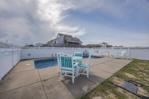 A backyard with a swimming pool, two lounge chairs, and a white fence. - 4755 - The OBX Rx, Semi-oceanfront! (Kitty Hawk)