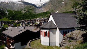 A mountain village with a church, houses, and a snow-capped mountain in the background. - GOLF Apartments Appartement/Fewo 4-Bettwohnung Nr. 3 by Interhome (Saas-Fee)