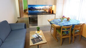 A compact living space with a kitchenette, a dining area, and a sofa. - GOLF Apartments Appartement/Fewo 4-Bettwohnung Nr. 3 by Interhome (Saas-Fee)