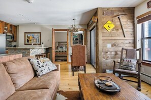 A cozy living room with a sofa, a coffee table, and a fireplace. - Upscale Condo in Downtown with Ski In Access, Pool, Hot Tubs, Fitness Center (Breckenridge)