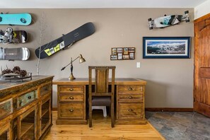 A room with a desk, drawers, a chair, a lamp, and a wall with skateboards and pictures. - Upscale Condo in Downtown with Ski In Access, Pool, Hot Tubs, Fitness Center (Breckenridge)