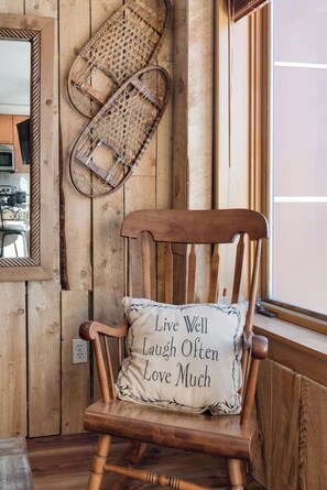 A wooden rocking chair with a cushion that has a motivational quote. - Peak 9 Inn 4512: Stellar Views - Downtown & Ski In Ski Out @ Base of Peak 9 (Breckenridge)