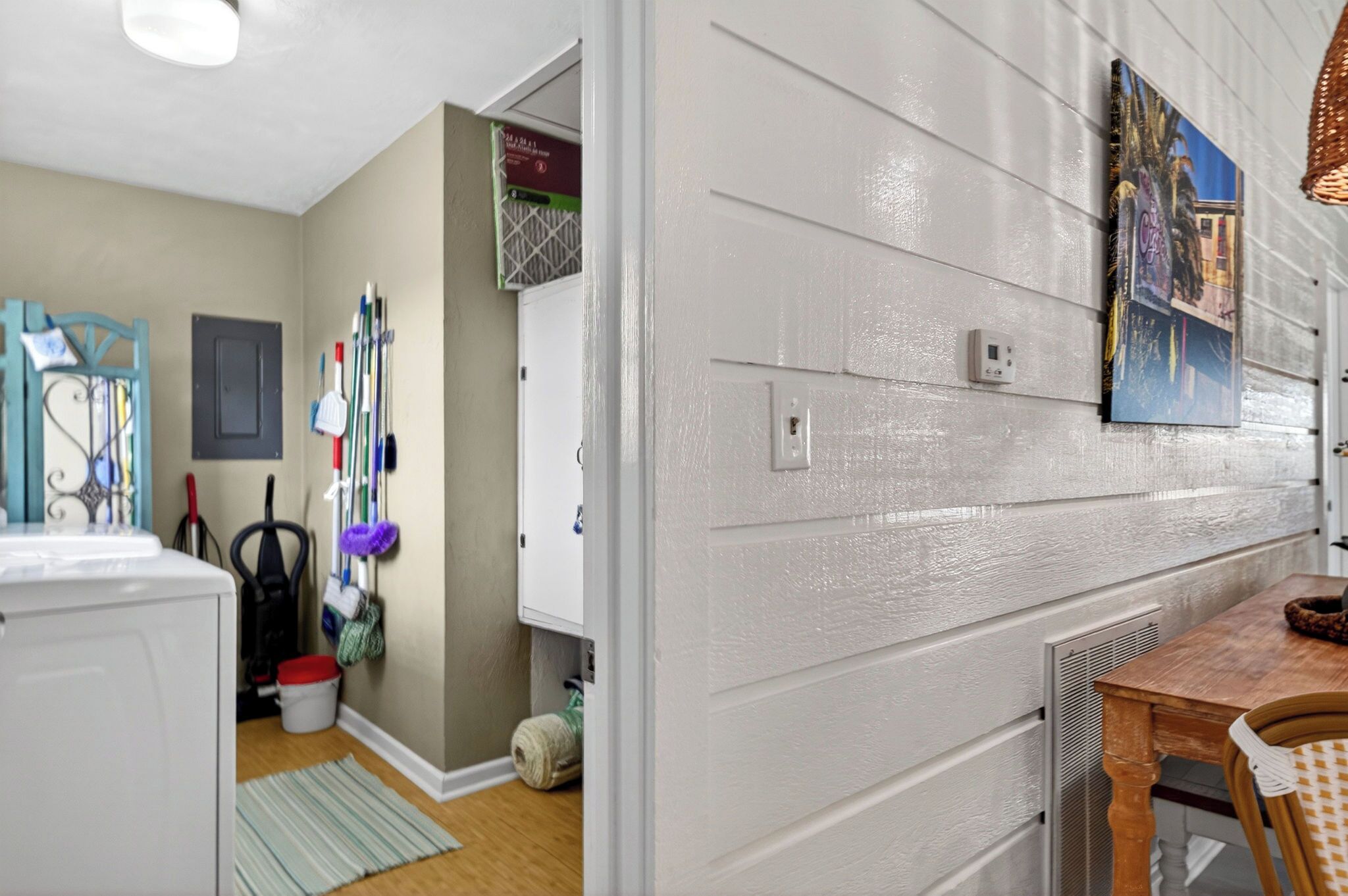 A laundry area with a washing machine, a drying rack, and cleaning supplies.