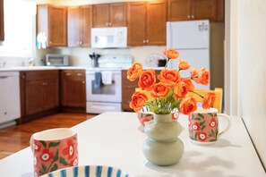 A kitchen with wooden cabinets, a microwave, and a white refrigerator. - Savannah Home, Walkable to Forsyth, Historic (Savannah)