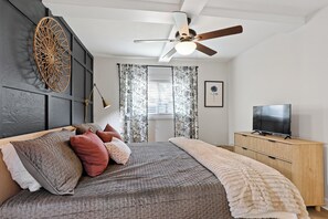 A bedroom with a bed, a ceiling fan, a TV, and a wooden cabinet. - Savannah, 2bed/2bath, Pet Friendly (Savannah)