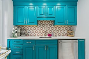 A kitchen with teal cabinets, a white countertop, and a patterned backsplash. - Downtown Savannah * Fun Studio on Jones Street * Walk to Forsyth * Dogs OK (Savannah)