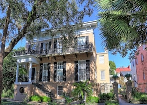 A two-story building with a balcony, a covered porch, and a staircase leading to the entrance. - Downtown Savannah * Fun Studio on Jones Street * Walk to Forsyth * Dogs OK (Savannah)