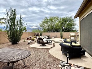 Eine Terrassesitzgruppe mit Tisch und einer großen Pflanze.