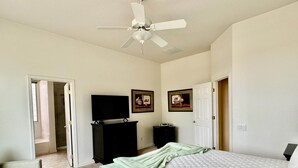A bedroom with a bed, a television, a dresser, and a ceiling fan. - Oro Valley Home For Rent w/ Spa & Views (Oro Valley)