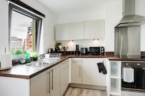 A modern kitchen with a stainless steel sink, a built-in oven, and a microwave. - Stylish Canal views Sleeps 8 | City Leeds Location (Leeds)